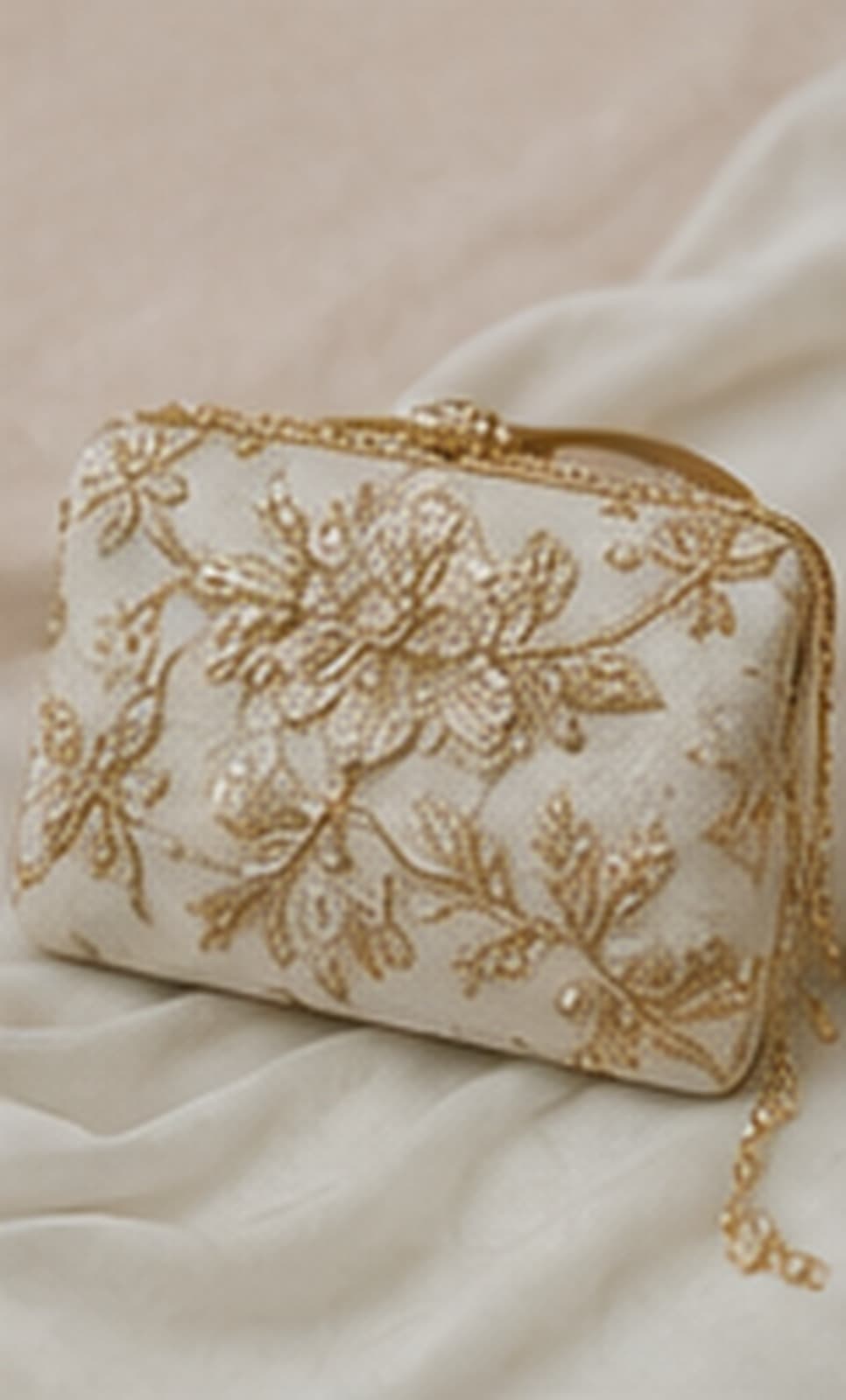Étude d’une pochette ivoire aux broderies champagne.